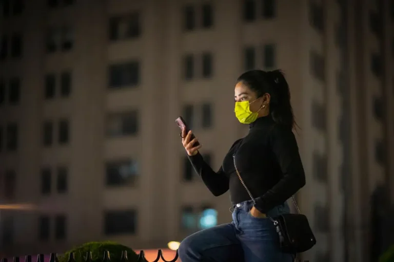 Femme consultant son téléphone dans la rue le soir